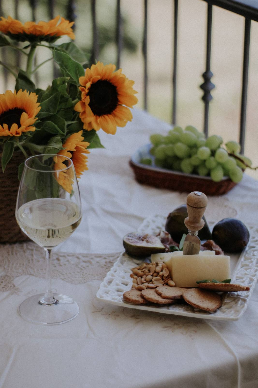 Gedeckter Tisch mit Käse, Trauben und Weißwein